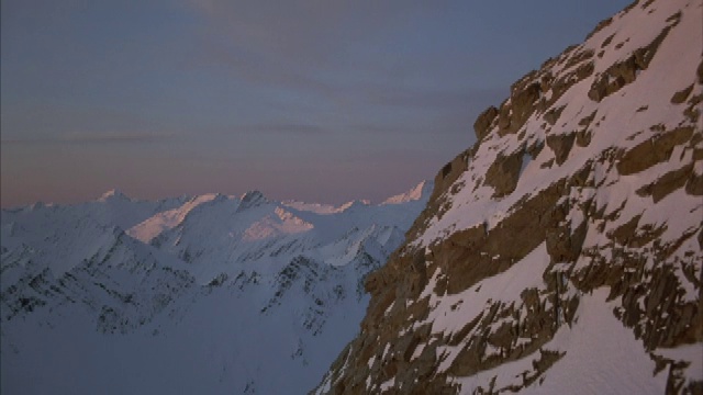 积雪覆盖着岩石嶙峋的山峰。视频素材