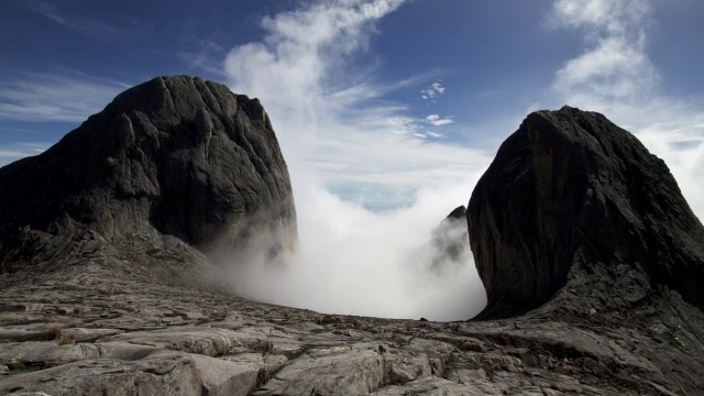 在婆罗洲基纳巴卢山的岩石山峰上，流逝的云滚滚而过视频素材