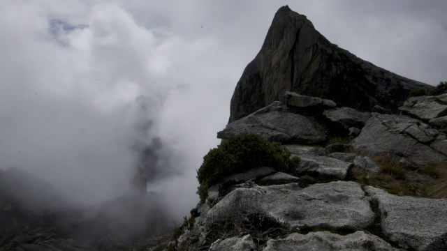 在婆罗洲基纳巴卢山的岩石山峰上，时间推移的云翻腾视频素材