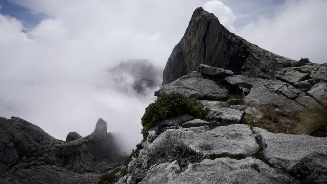 在婆罗洲基纳巴卢山的岩石山峰上，流逝的云滚滚而过视频素材