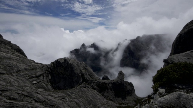 在婆罗洲基纳巴卢山的岩石山峰上，流逝的云滚滚而过视频素材