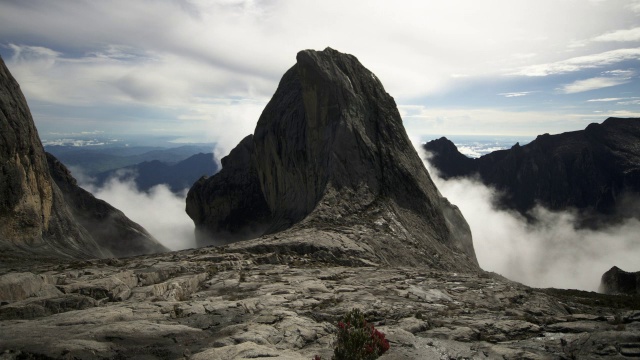 在婆罗洲基纳巴卢山的岩石山峰上，时间推移的云翻腾视频素材