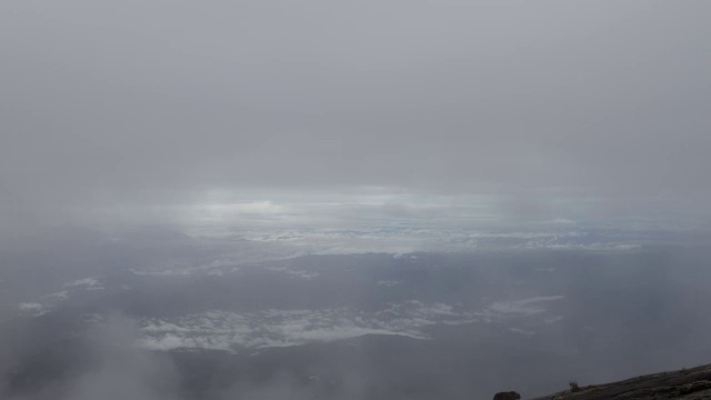 在婆罗洲基纳巴卢山的岩石山峰上，流逝的云滚滚而过视频素材