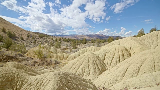 不毛之地黄色粘土约翰戴化石床的形成云和阴影漂移在一个偏远的沙漠山萨顿山靠近画山8视频素材