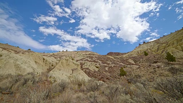 不毛之地，黄色粘土，约翰戴化石床，形成，云和阴影漂移在一个偏远的沙漠山萨顿山附近的彩山10视频素材