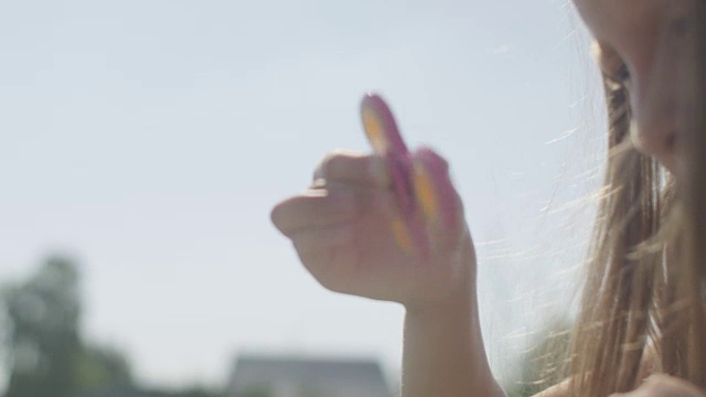 夏天，女孩在户外玩纺纱机视频素材画面2