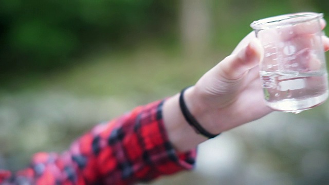 女孩探险家在烧杯中检查水样用于STEM研究视频素材画面1