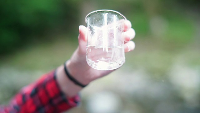 女孩探险家在烧杯中检查水样用于STEM研究视频素材画面2