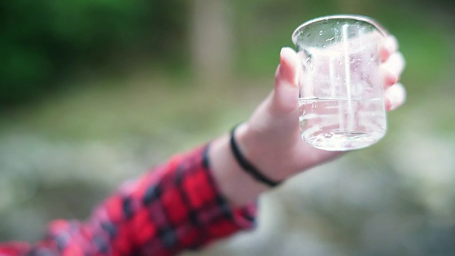 女孩探险家在烧杯中检查水样用于STEM研究视频素材画面3