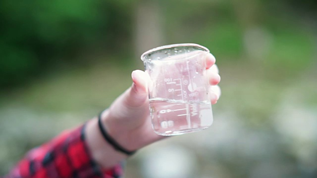 女孩探险家在烧杯中检查水样用于STEM研究视频素材画面4
