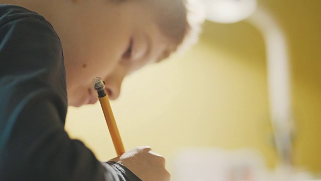 男孩(10-11)在书桌上做作业的特写视频素材画面4