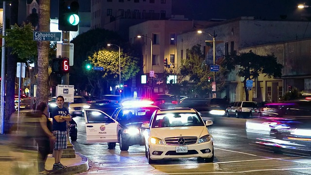 WS ZI T/L十字路口的交通和洛杉矶警察局警车的背景/美国加州好莱坞。视频素材