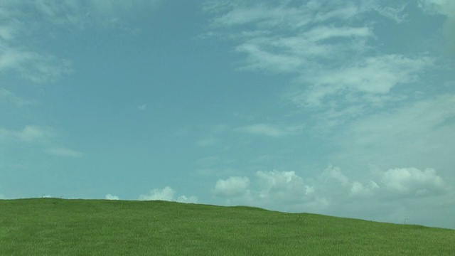 在绿色的田野上空云朵的时间流逝视频素材画面1