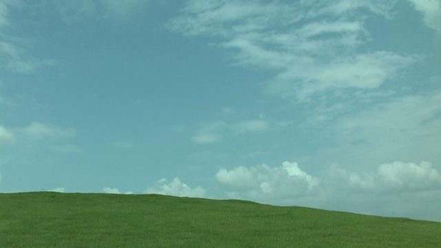 在绿色的田野上空云朵的时间流逝视频素材画面2