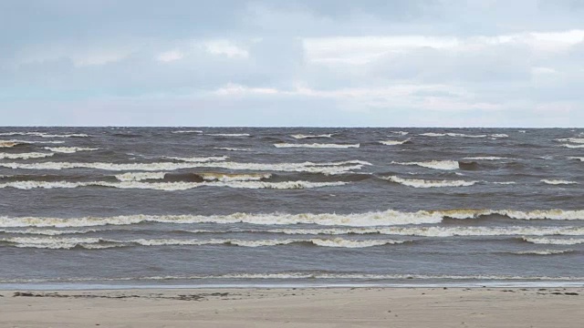 波涛汹涌的大海，海鸥在蔚蓝的天空。视频。美丽的海景，有鸟，波浪，白色的泡沫，微风，飞溅，沙子视频素材