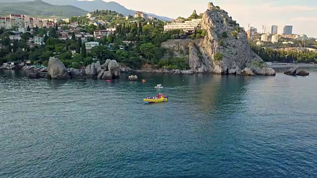 无人机飞行拍摄的邮轮旅游双体船通过海洋岩石海岸视频素材