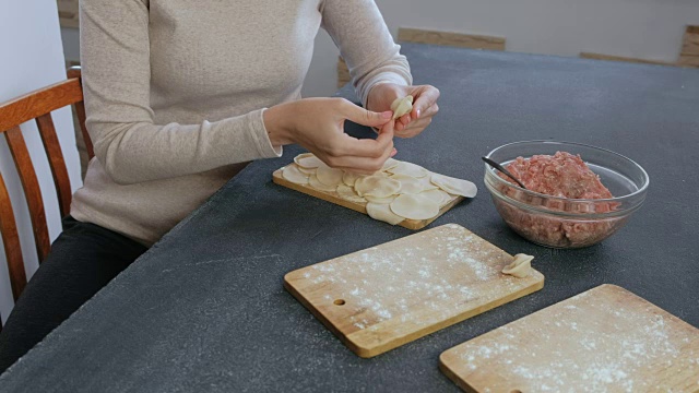 女人用碎肉包饺子，特写的手。视频素材