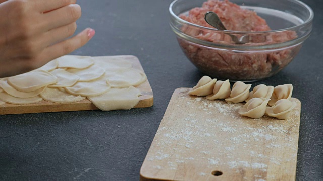 女人用碎肉包饺子，特写的手。视频素材