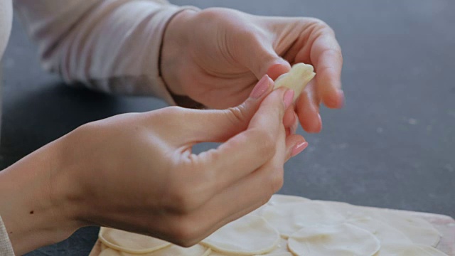 女人用碎肉包饺子，特写的手。视频素材