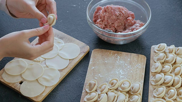 女人用碎肉包饺子，特写的手。视频素材