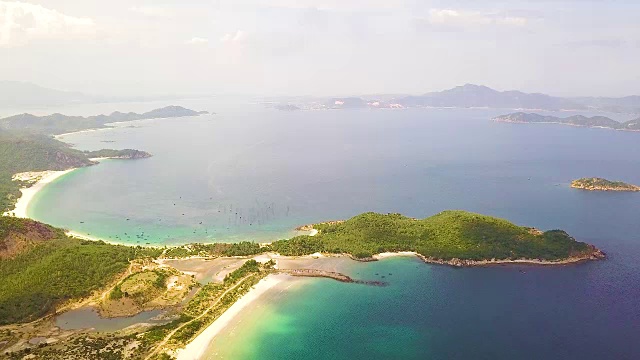 无人机俯瞰海湾和绿色岛屿。蓝色的大海，沙滩和绿色的岛屿在空中的天际线景观视频素材