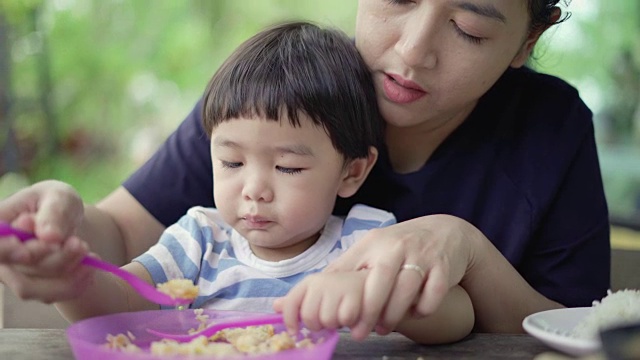 可爱的婴儿和妈妈一起吃东西视频素材