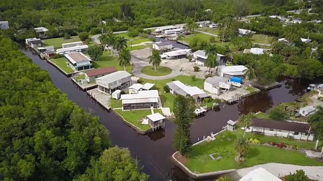 沼泽地住宅区的空中俯瞰，从河上的小船上向上倾斜视频素材