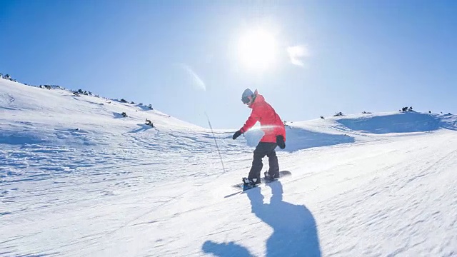 滑雪者享受阳光明媚的冬日，表演跳跃特技滑下滑雪坡视频素材