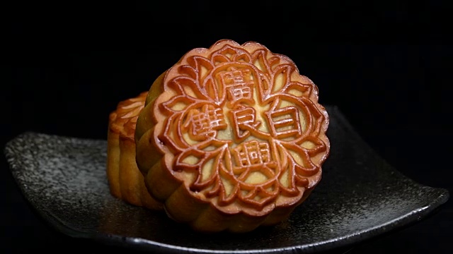 中秋节期间向朋友或家庭聚会提供月饼/月饼和中国茶/月饼上的汉字代表“重白”的英文视频素材画面1