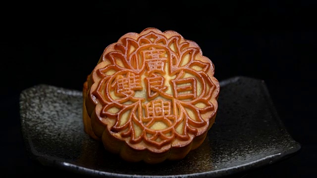 中秋节期间向朋友或家庭聚会提供月饼/月饼和中国茶/月饼上的汉字代表“重白”的英文视频素材画面2