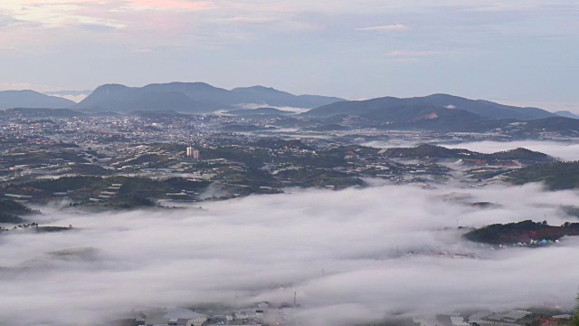 城市在山脚下的晨雾与山背景-大拉，越南视频素材