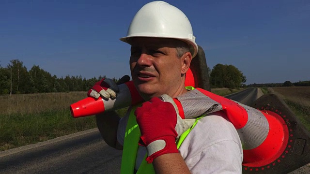 道路建筑工人肩上有两个交通锥视频素材画面3