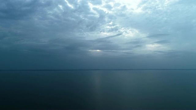 在雨云的背景下，在美丽的海面上飞行。时间流逝视频素材