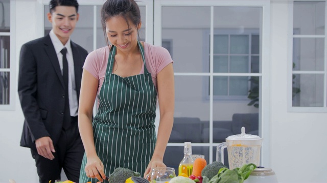 厨房里一对可爱的夫妇。夫妇烹饪健康的食物在厨房生活方式餐准备视频素材