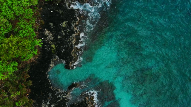 热带地区蓝色海洋和黑色岩石的鸟瞰图。视频素材