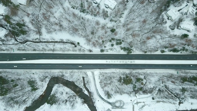 空中拉回拍摄雪道上的汽车视频素材