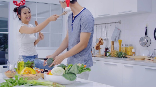 一对夫妇在家里的厨房里一起做饭。夫妇烹饪健康的食物在厨房生活方式餐准备。视频素材