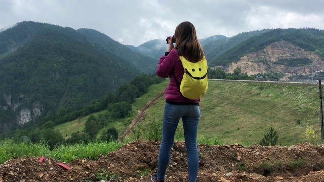 一名女子在阴雨天从高处拍摄自然风景视频素材