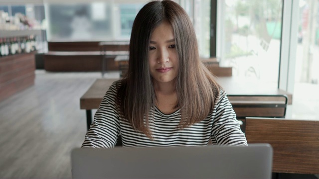 压力亚洲年轻女子头痛时使用笔记本电脑在咖啡馆视频素材