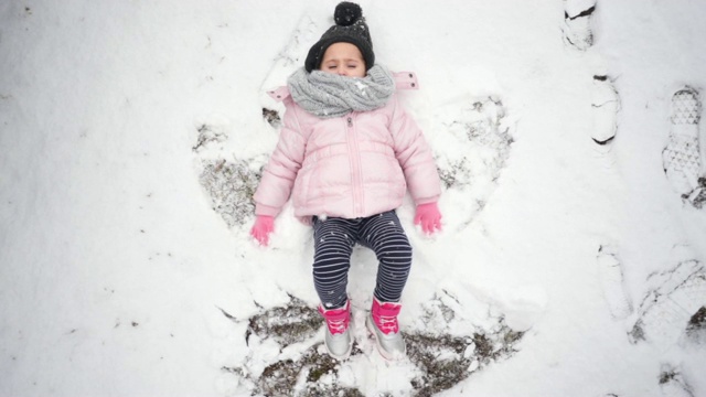 可爱的孩子在雪地里玩雪人视频素材