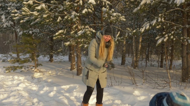 欢乐的男孩和女孩在森林里玩雪球在寒假视频素材