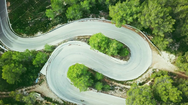 鸟瞰图视频的两车道蜿蜒的道路在森林与自行车和汽车视频素材