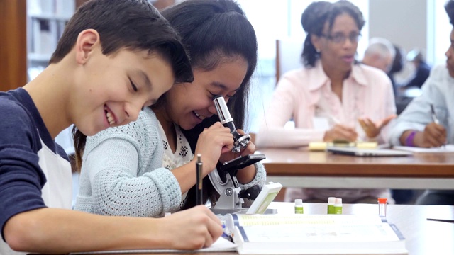 小学生在做科学作业时兴奋地碰拳视频素材