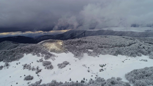 鸟瞰图的冬季山在雾，在白雪覆盖的森林视频素材