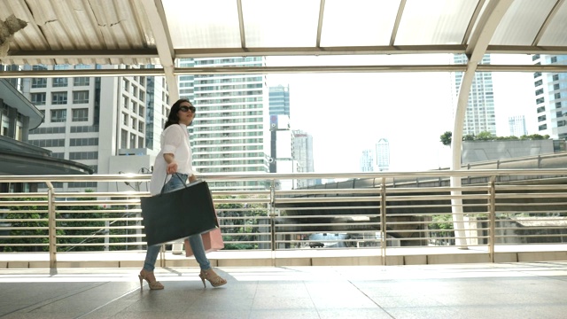 购物女人微笑着购物袋在城市视频素材