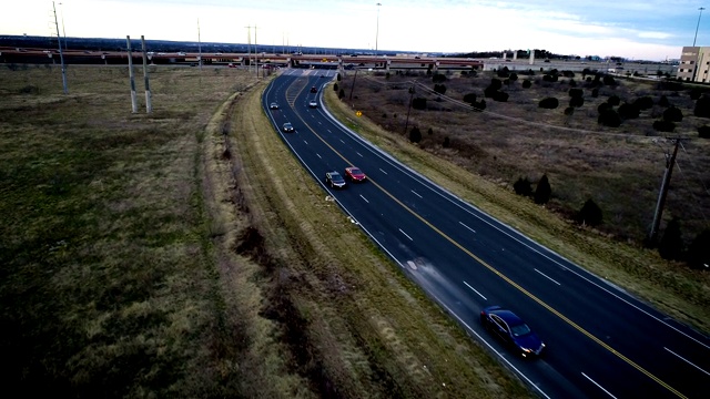 慢镜头:黑色道路两旁是空旷地带，车辆经过视频素材