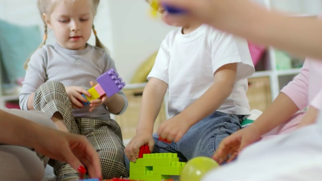 在幼儿园里，小朋友们玩着正在开发的建筑玩具视频素材