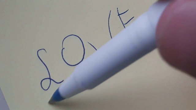 用笔在纸上写上“爱”。视频素材画面4