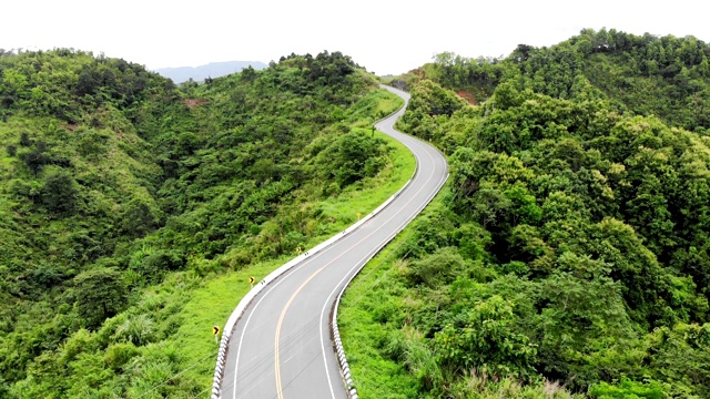 上面的柏油公路穿过山谷顶部的热带雨林视频素材