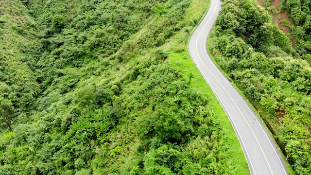 上面的柏油公路穿过山谷顶部的热带雨林视频素材